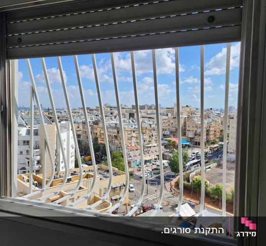 סורגים עם בטן ממתכת לבנה מותקנים בחלון דירה